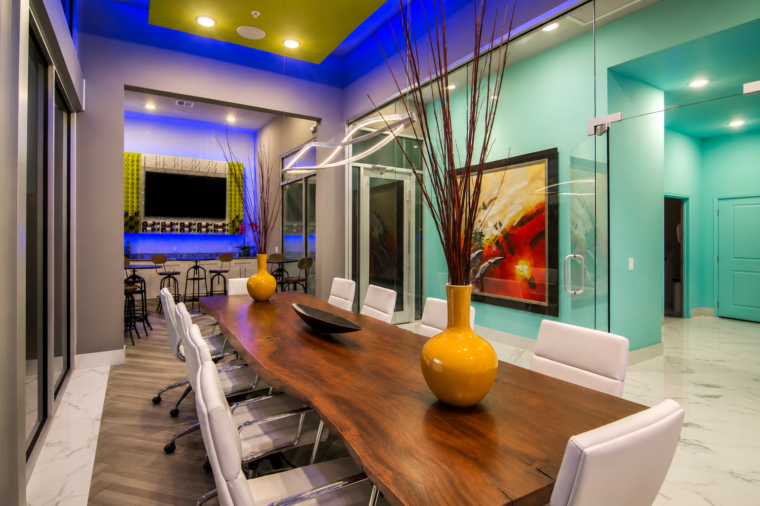 Modern Storage® West Little Rock conference room with colorful lighting, wood table, modern seating, and bold interior design